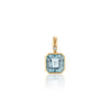 A gold pendant featuring a square-cut blue aquamarine gemstone and a small round diamond accent, shown on a clean white background with a soft reflection below.