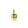 A gold pendant featuring a square-cut green peridot gemstone and a small round diamond accent, shown on a clean white background with a soft reflection below.