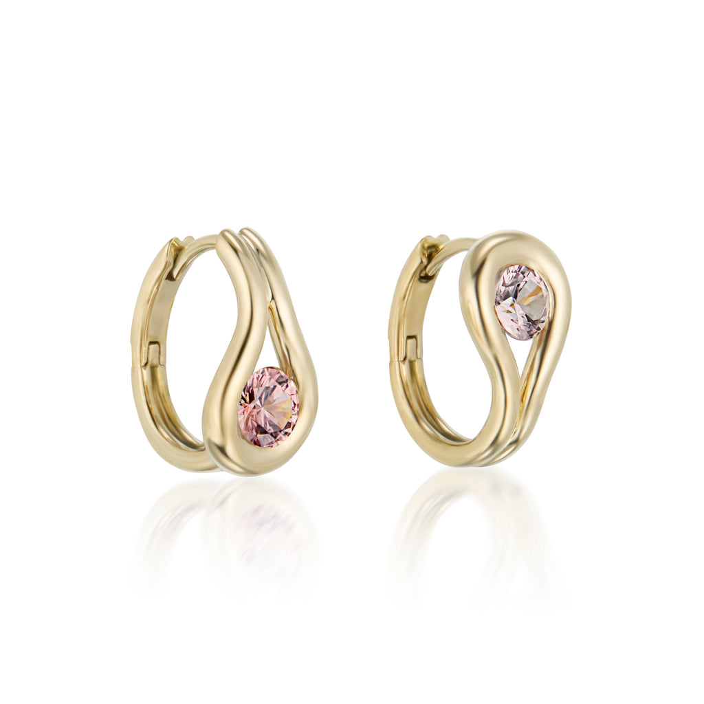 A pair of gold teardrop-shaped stud earrings with a round light pink gemstone in the center, malaya garnet, displayed on a clean white background with a soft reflection.
