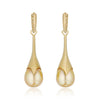 A pair of gold statement earrings, detachable pearl pendants on hoop earrings with a row of pavé-set ombre yellow diamond stones along the front edge, shown on a clean white background with a soft reflection below.