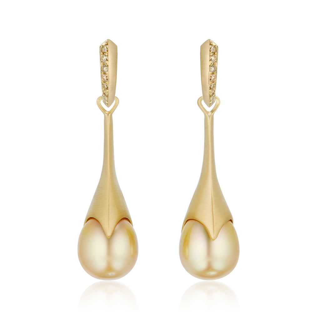 A pair of gold statement earrings, detachable pearl pendants on hoop earrings with a row of pavé-set ombre yellow diamond stones along the front edge, shown on a clean white background with a soft reflection below.