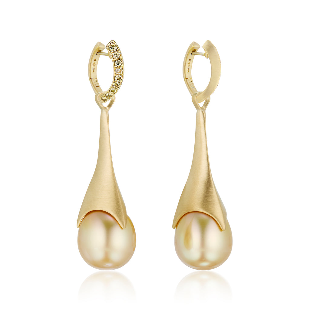 A pair of golden teardrop statement earrings, detachable pearl pendants on hoop earrings with a row of pavé-set ombre yellow diamond stones along the front edge, shown on a clean white background with a soft reflection below.