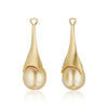 A pair of golden teardrop statement earrings, detachable pearl pendants, shown on a clean white background with a soft reflection below.
